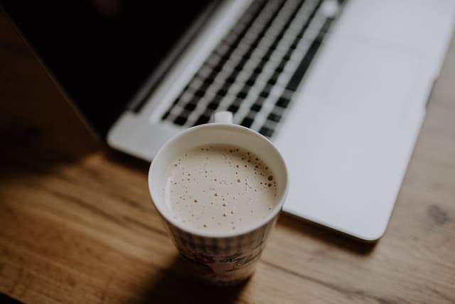 Coffee near the laptop closeup. Working from home.